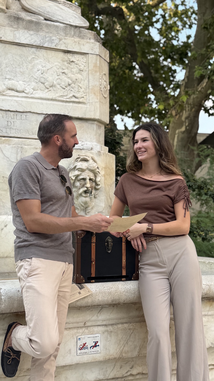 Deux personnes échangent à côté de la malle signature Timeless
